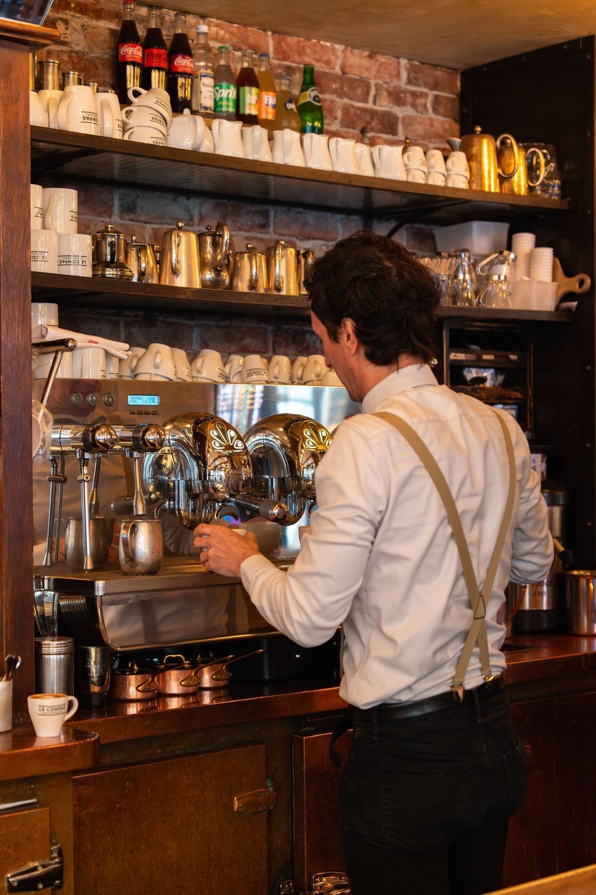 Un serveur prépare le café derrière le comptoir